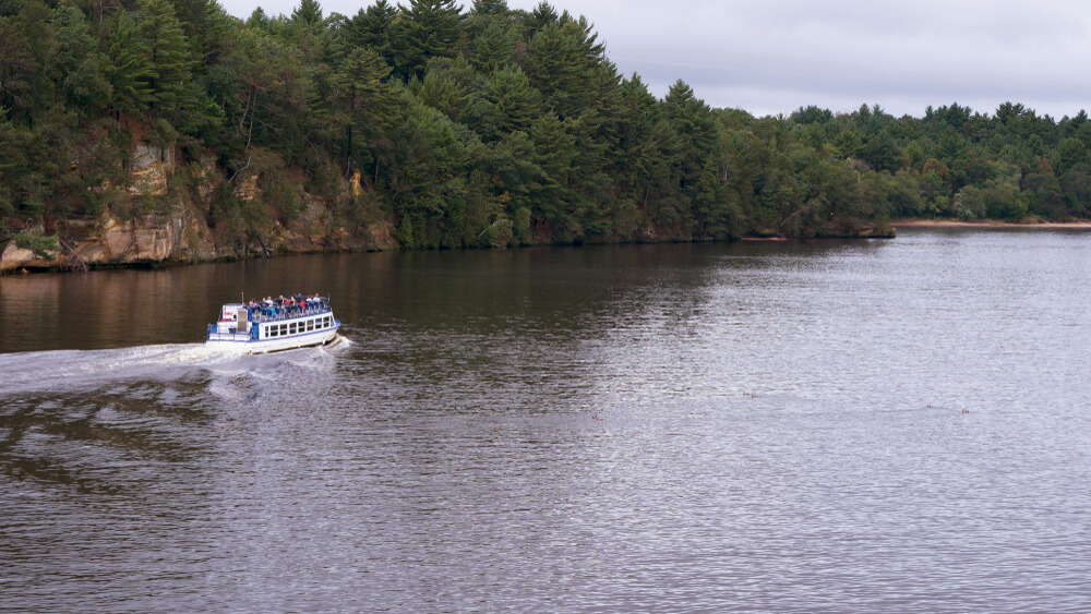 Boat driving down the Wisconsin River on Wisconsin Dells boat tours